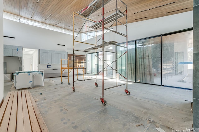 unfurnished room with a high ceiling and concrete floors