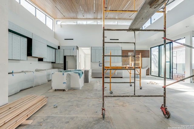 interior space with unfinished concrete flooring and a towering ceiling