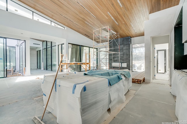 interior space featuring high vaulted ceiling, concrete floors, and wood ceiling