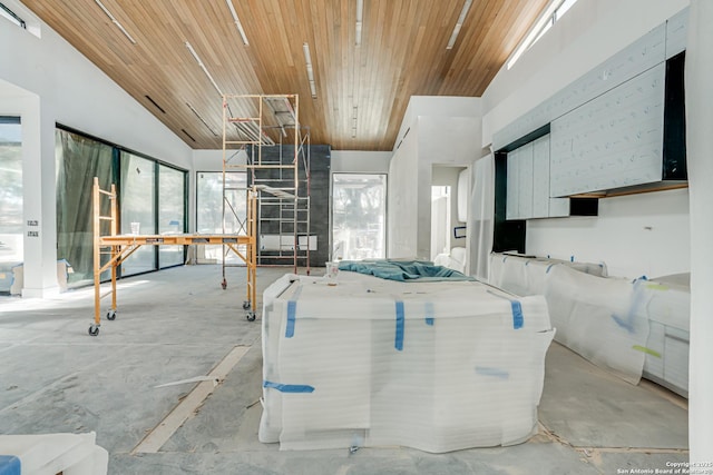 kitchen with wooden ceiling, a healthy amount of sunlight, concrete floors, and modern cabinets