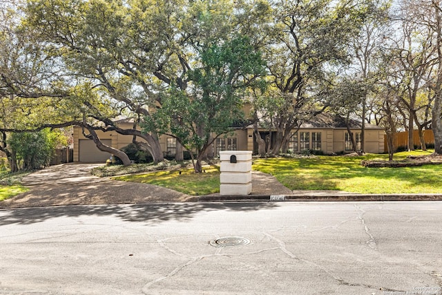 view of front of house featuring decorative driveway and a front lawn