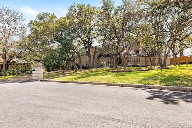 view of front of house featuring fence and a front lawn