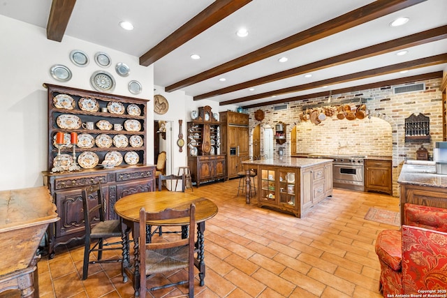 dining space with brick wall, beam ceiling, and recessed lighting