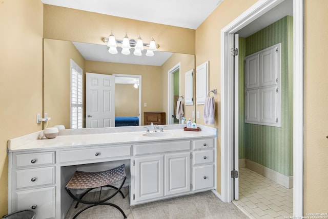 ensuite bathroom featuring vanity, baseboards, and ensuite bathroom