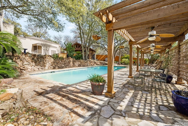 outdoor pool with a ceiling fan, a fenced backyard, a patio area, a pergola, and outdoor dining space