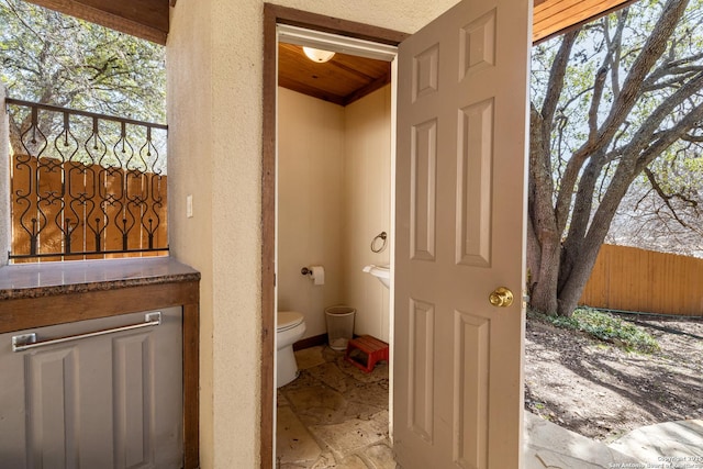 bathroom featuring a textured wall and stone tile floors