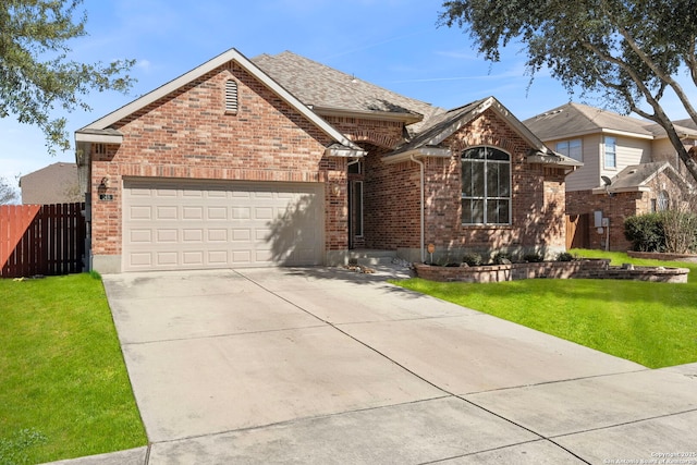 ranch-style house with a front yard, brick siding, fence, and an attached garage