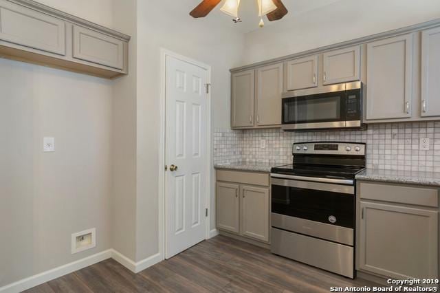 kitchen with gray cabinets, appliances with stainless steel finishes, decorative backsplash, and dark wood finished floors