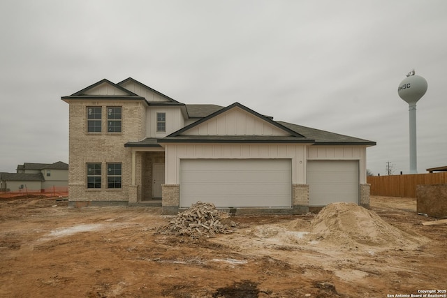 craftsman house featuring an attached garage, brick siding, fence, roof with shingles, and board and batten siding