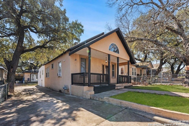 view of front of property featuring fence, a porch, and stucco siding