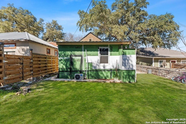 rear view of house featuring a yard, ac unit, fence, and stucco siding