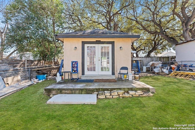 view of outdoor structure featuring a fenced backyard, french doors, and an outbuilding