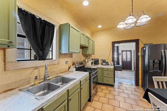 kitchen featuring pendant lighting, black fridge, stainless steel range with gas cooktop, and green cabinetry