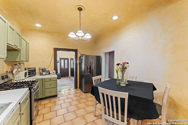 kitchen featuring green cabinetry, light countertops, appliances with stainless steel finishes, hanging light fixtures, and an inviting chandelier