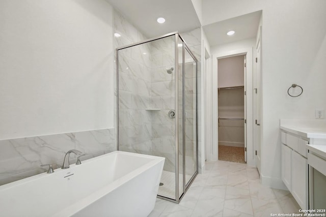 12440 Lanthimos, San Antonio, TX 78254 - bathroom featuring a walk in closet, a soaking tub, a stall shower, and marble finish floor