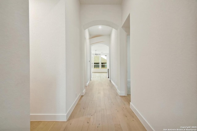 12440 Lanthimos, San Antonio, TX 78254 - corridor with arched walkways, baseboards, and light wood-type flooring