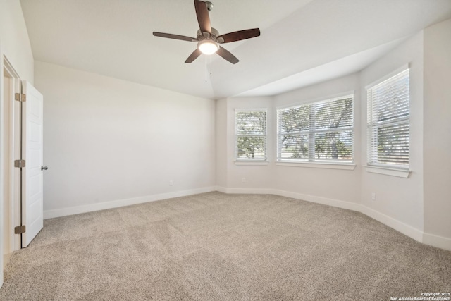 unfurnished room with baseboards, a ceiling fan, and light colored carpet