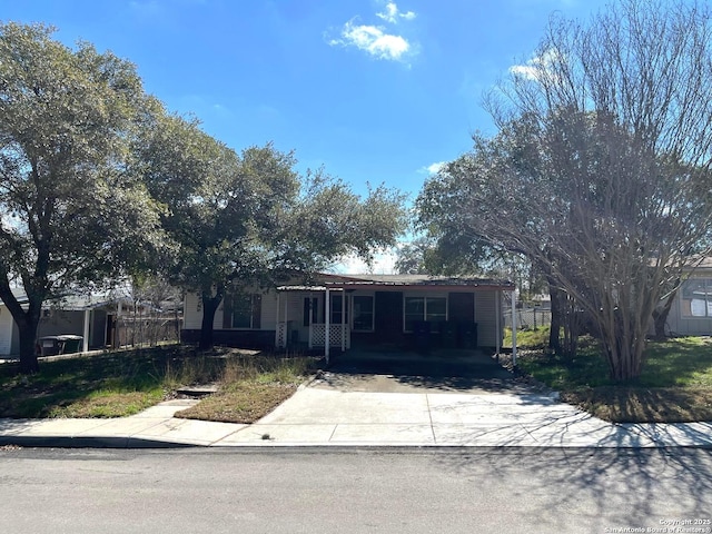 single story home featuring concrete driveway and a carport