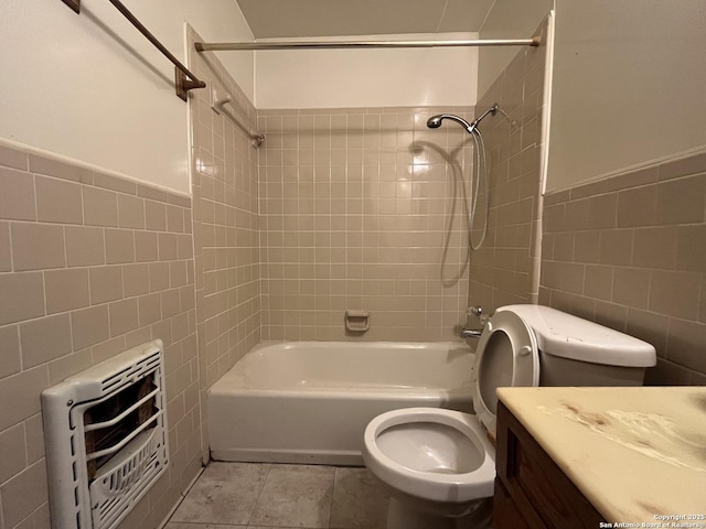 full bath with bathing tub / shower combination, tile walls, heating unit, vanity, and tile patterned flooring