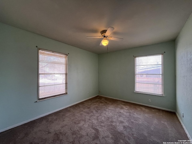 carpeted spare room with baseboards and a ceiling fan