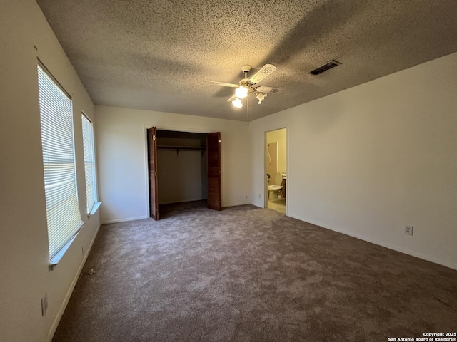 unfurnished bedroom with a textured ceiling, carpet floors, ceiling fan, and visible vents