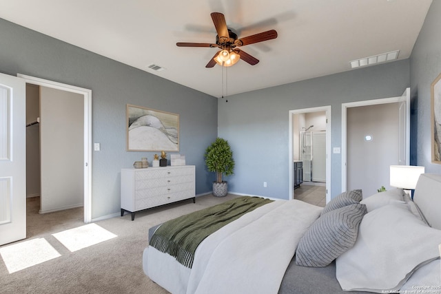 bedroom featuring carpet, ensuite bath, visible vents, and a ceiling fan