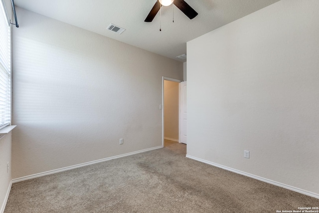 spare room with baseboards, visible vents, ceiling fan, and carpet flooring