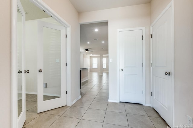 hall with light tile patterned floors, recessed lighting, baseboards, and french doors