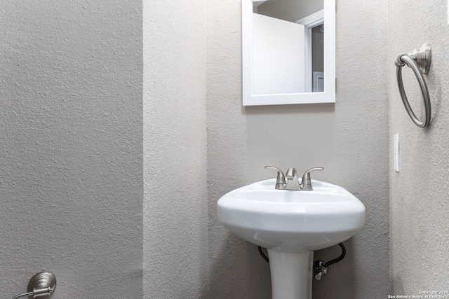 bathroom with a textured wall and a sink