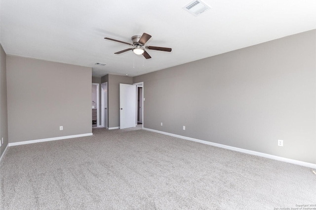 empty room with carpet floors, baseboards, visible vents, and a ceiling fan