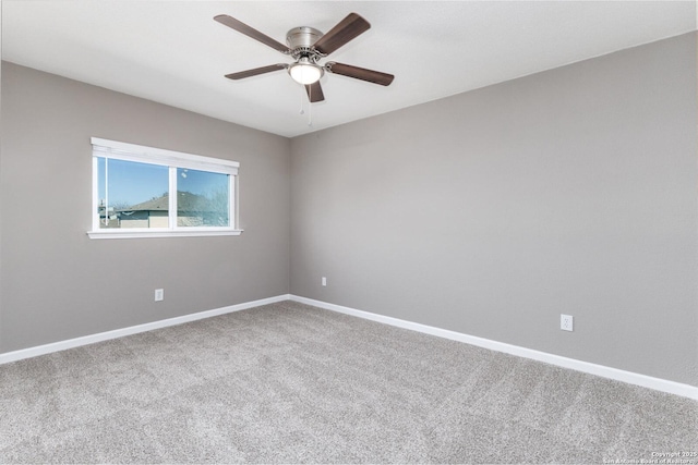 unfurnished room with carpet flooring, a ceiling fan, and baseboards