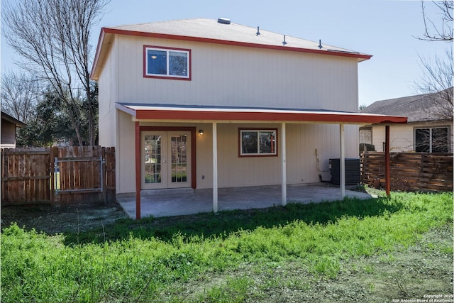 rear view of property with cooling unit, french doors, a patio area, and fence