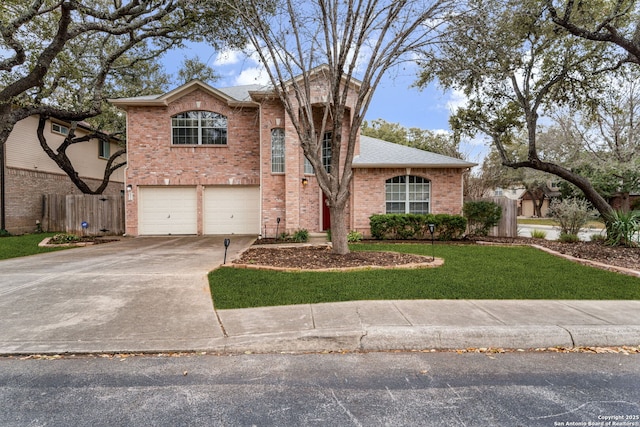 traditional home with driveway, a garage, brick siding, fence, and a front yard