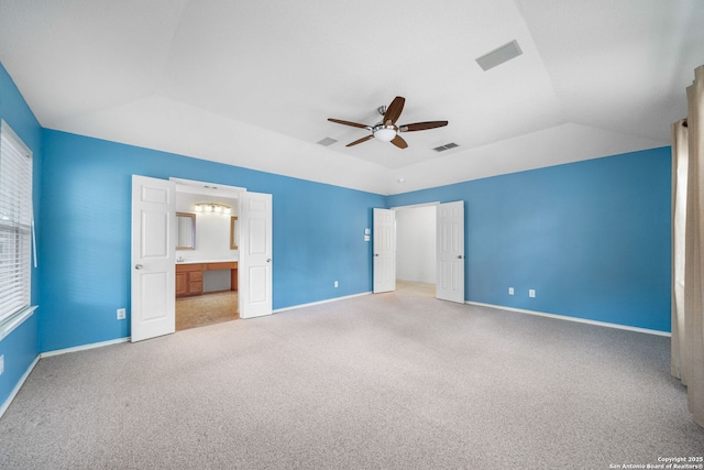 unfurnished bedroom with light carpet, visible vents, baseboards, and vaulted ceiling