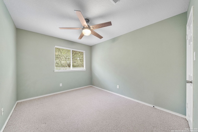 spare room with carpet, baseboards, ceiling fan, and a textured ceiling