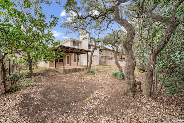 rear view of property featuring brick siding, a patio area, fence, and a pergola