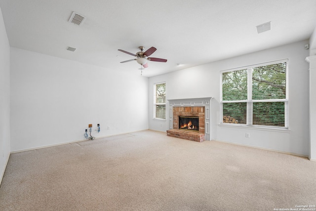 unfurnished living room with visible vents, a fireplace, carpet flooring, and ceiling fan