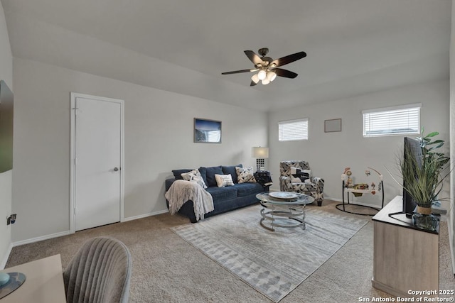 living area featuring light colored carpet, ceiling fan, and baseboards