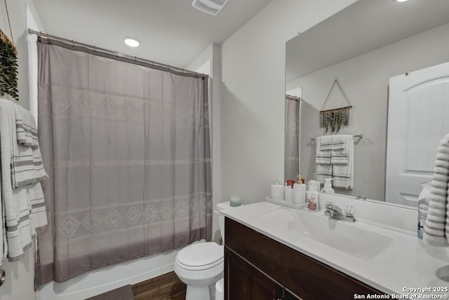 bathroom featuring toilet, shower / tub combo, wood finished floors, vanity, and visible vents