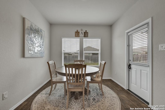 dining space featuring baseboards and dark wood-type flooring