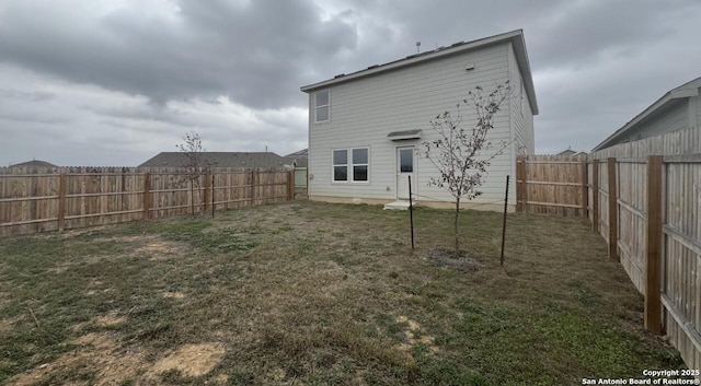 back of property with a yard and a fenced backyard