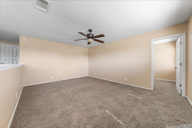 carpeted empty room featuring baseboards, a textured ceiling, visible vents, and a ceiling fan