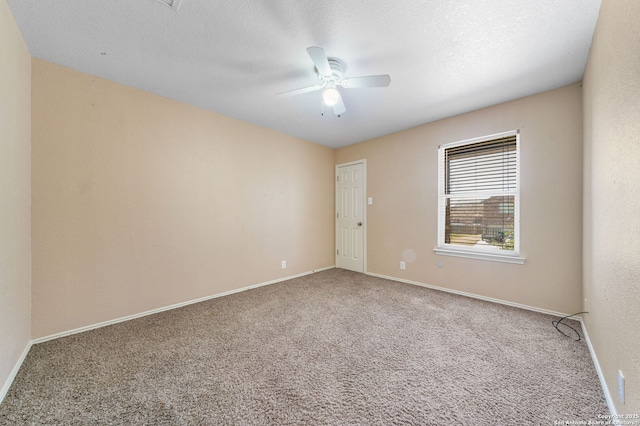 spare room featuring a ceiling fan, a textured ceiling, baseboards, and carpet flooring