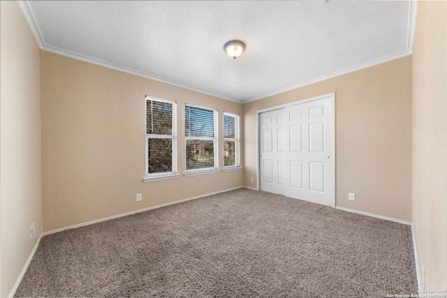 unfurnished bedroom featuring crown molding, baseboards, and carpet flooring