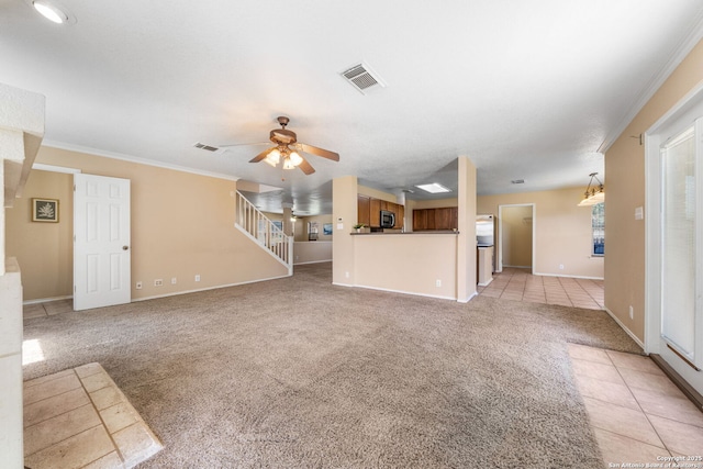 unfurnished living room featuring light carpet, visible vents, ceiling fan, ornamental molding, and light tile patterned flooring