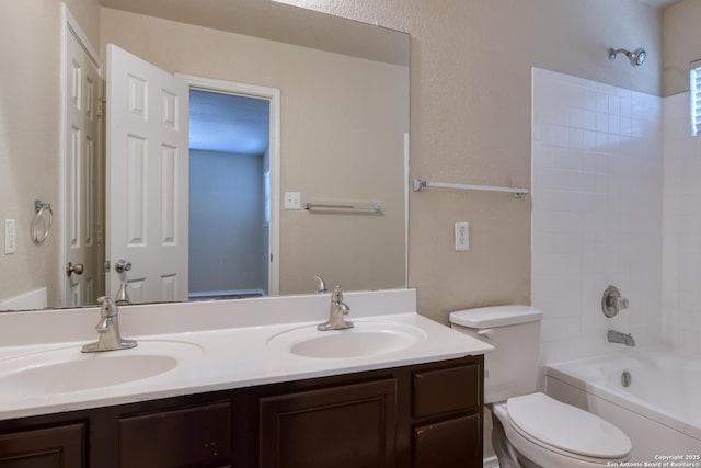 bathroom with toilet, double vanity, bathtub / shower combination, and a sink