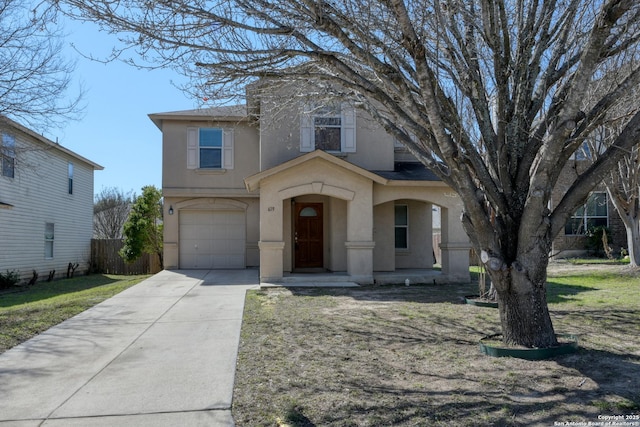 view of front of property featuring a garage, concrete driveway, fence, and stucco siding