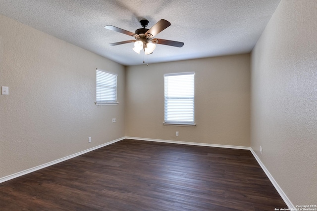 unfurnished room featuring a wealth of natural light, a textured wall, a textured ceiling, and wood finished floors