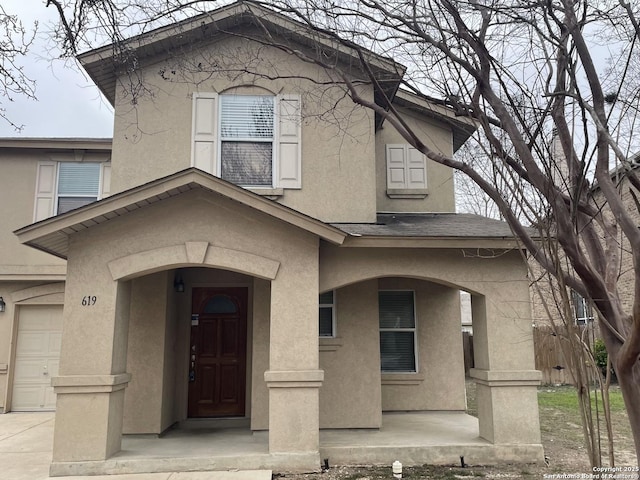 view of front of home featuring a shingled roof, a garage, and stucco siding