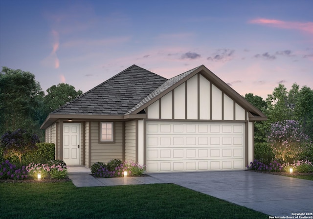 view of front of house featuring a garage, a front yard, driveway, and a shingled roof